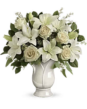 White lilies and cream roses arranged in a white vase