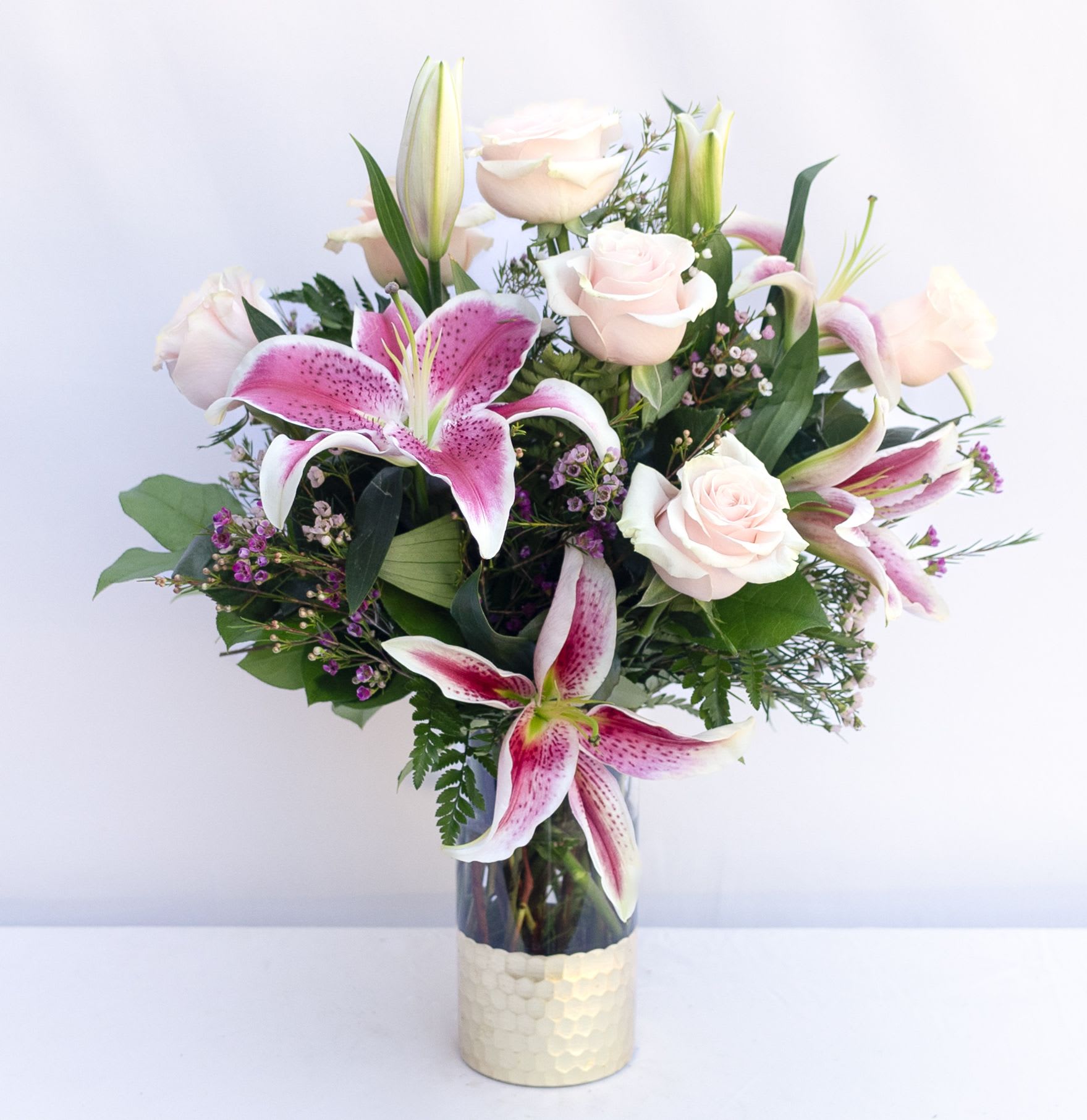 Simple Perfection - Pink Sorbone lilies accented with pink roses and filler vased with greenery.  if we sell out of Pink Lillies, we will be using white lillies. 