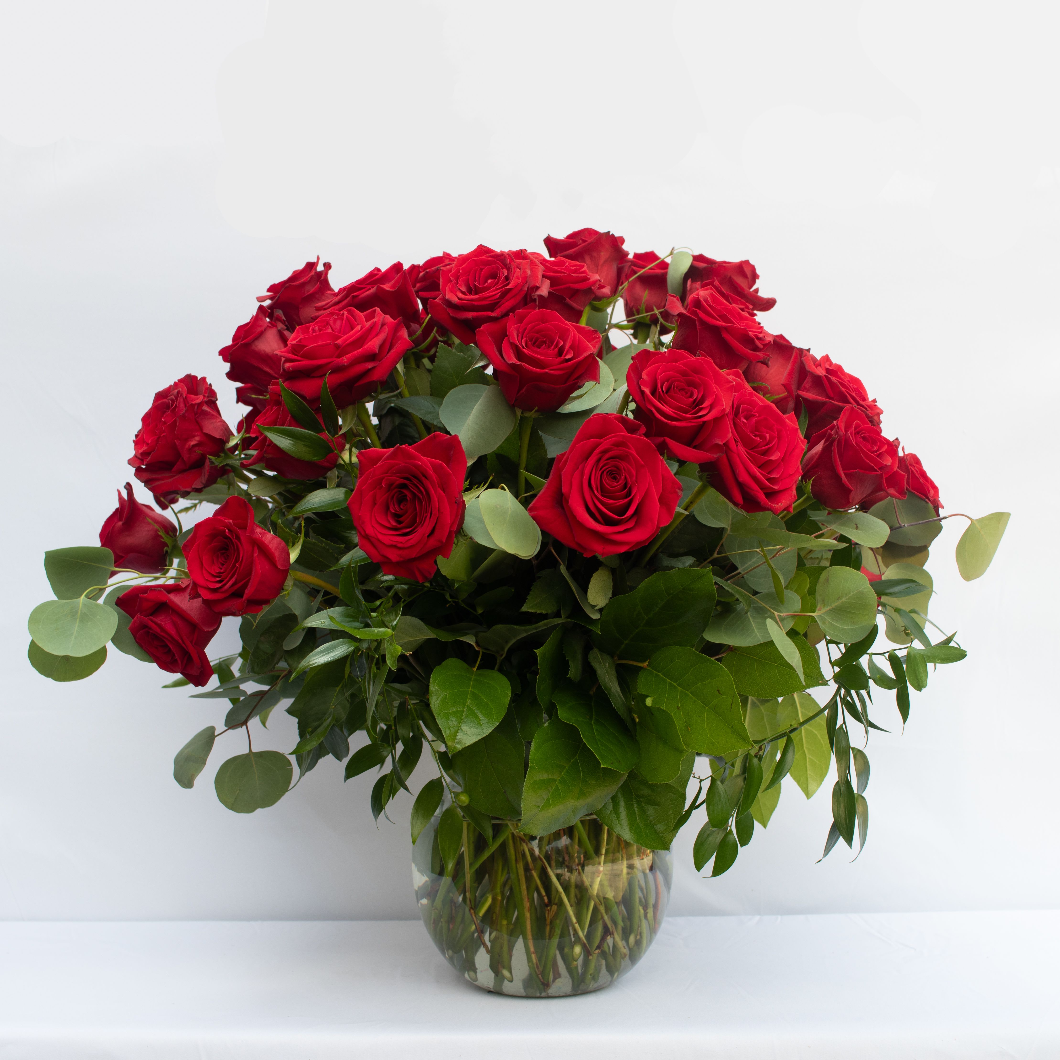 Red roses arranged in a clear glass vase