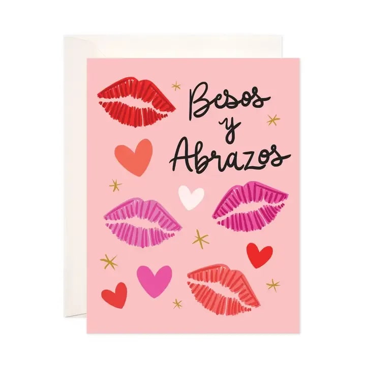Pink greeting card with lips, hearts, and "Besos y Abrazos" text