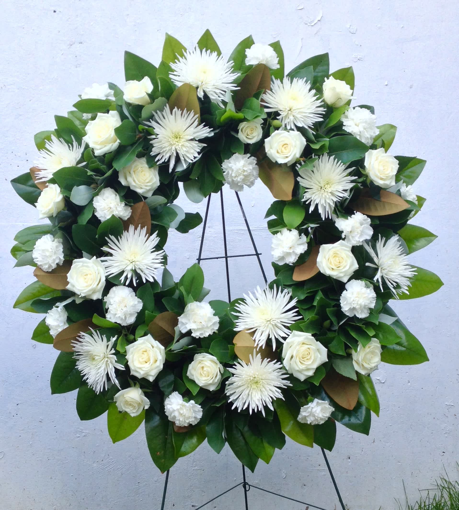 White rose and chrysanthemum wreath on a black stand