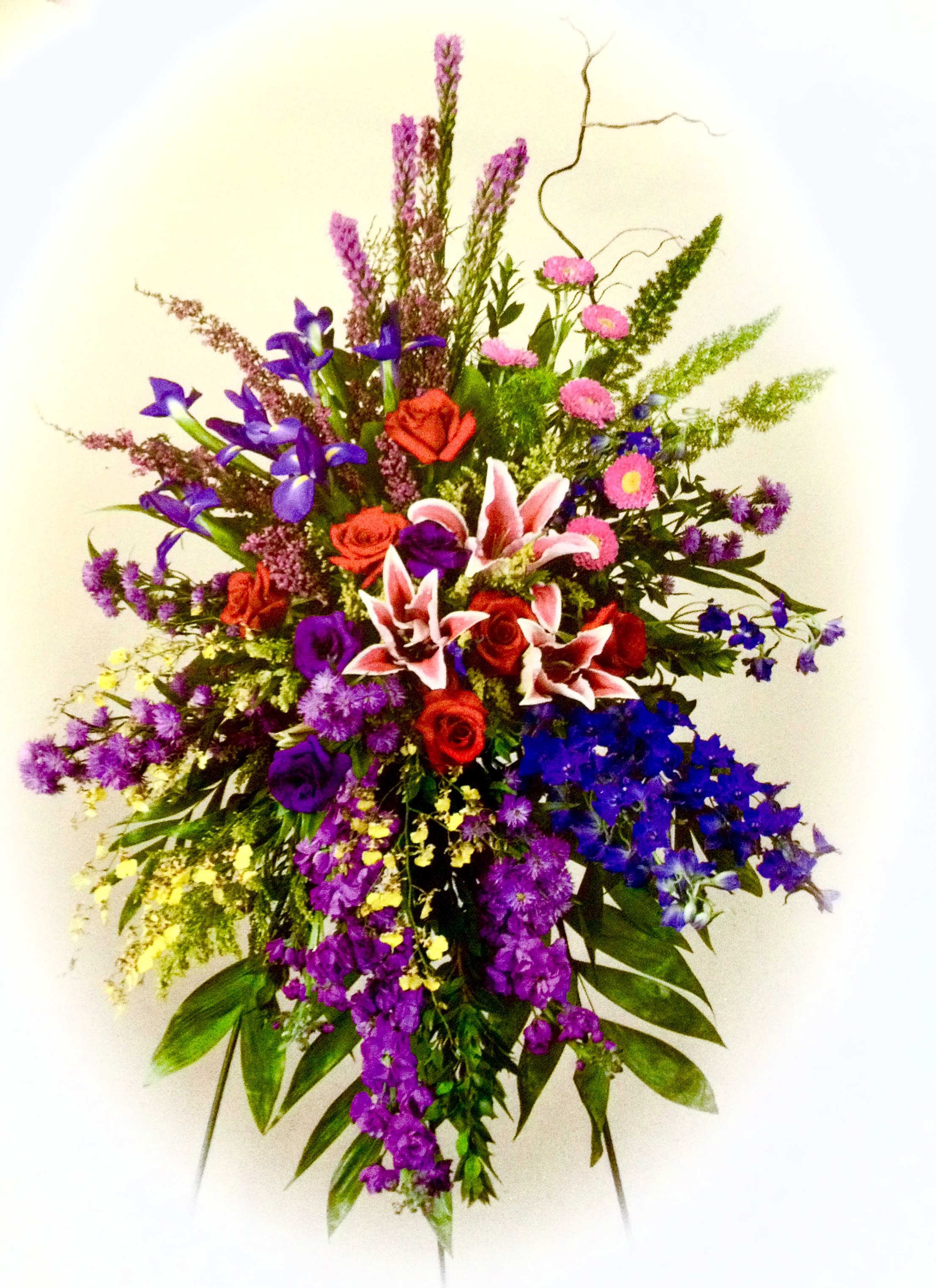 Tall mixed bouquet with red roses, pink lilies, and purple flowers