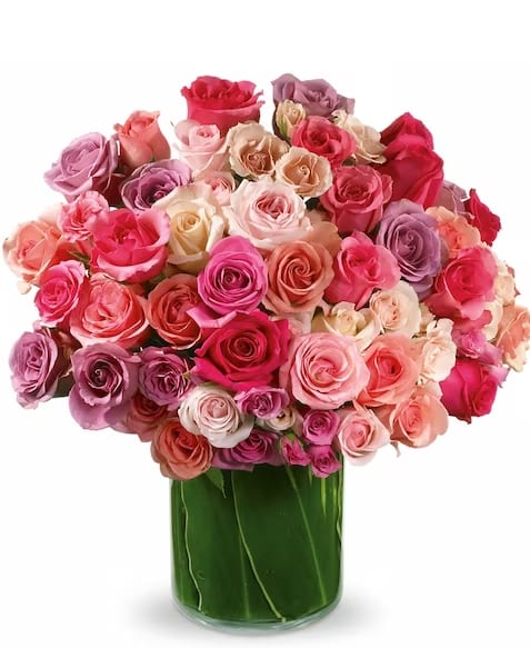 Bouquet of pink, peach, and lavender roses in a glass vase