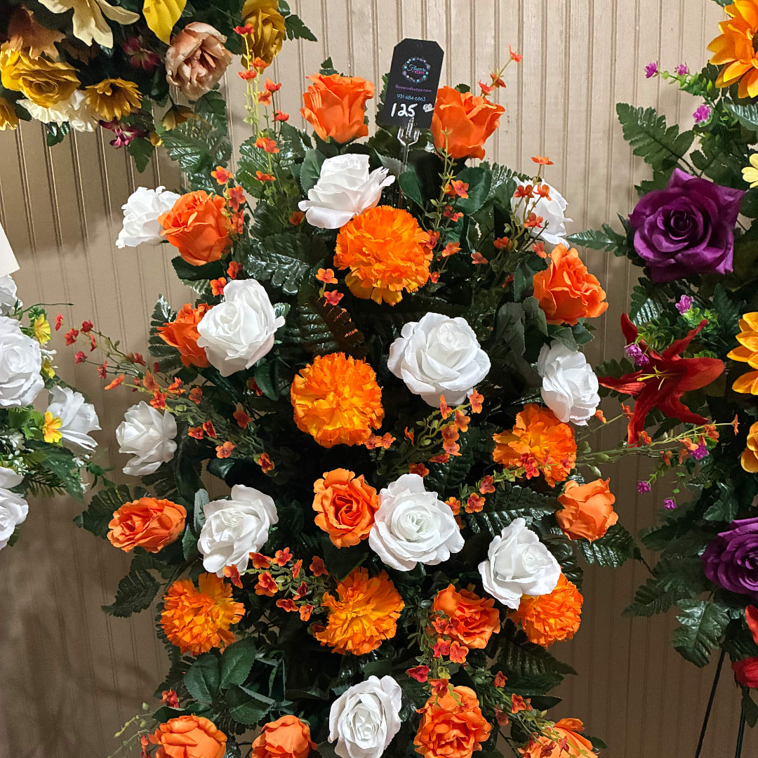 Orange and white rose arrangement with marigold-like blooms