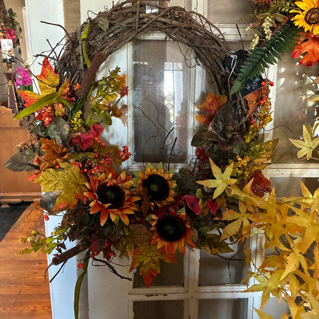 Autumn wreath with sunflowers, berries, and colorful leaves on a door