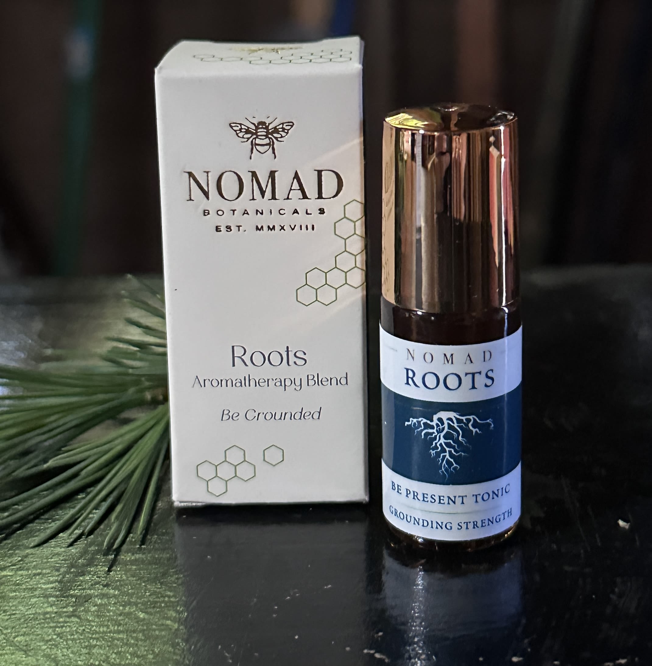 Roots Essential Oil Blend by Nomad Botanicals - Grounds your body/mind to harness root-like strength through being in the moment. Be grounded and present with this warm, earthy, elegant aromatherapy blend. Jojoba Oil-golden*; Essential Oils of Essential Oils of Palmarosa, Vetiver, Himalayan Cedarwood~; Balsam Fir Absolute (*organic, ~wild). 5 mil Made in Petaluma CA