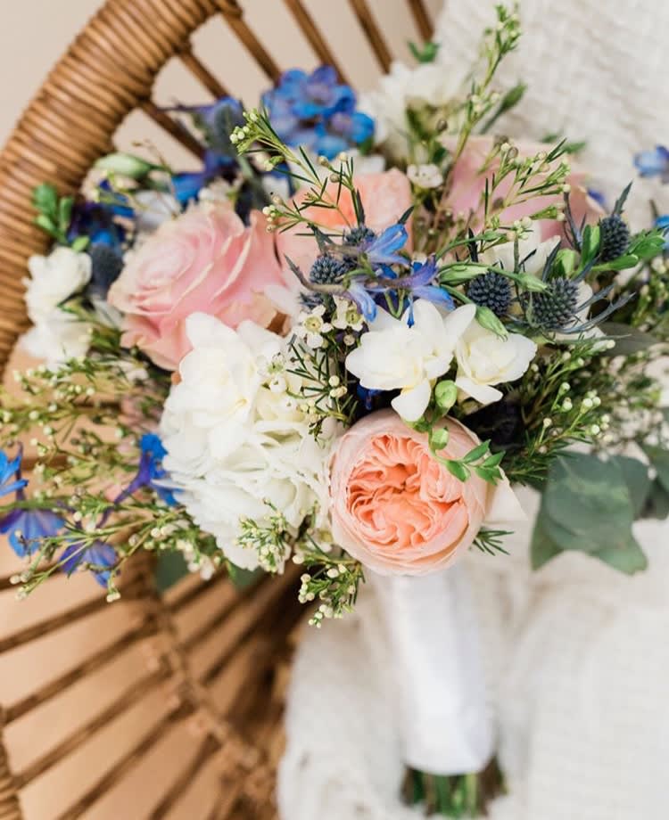 Hand-tied bouquet of pink, white, and blue flowers