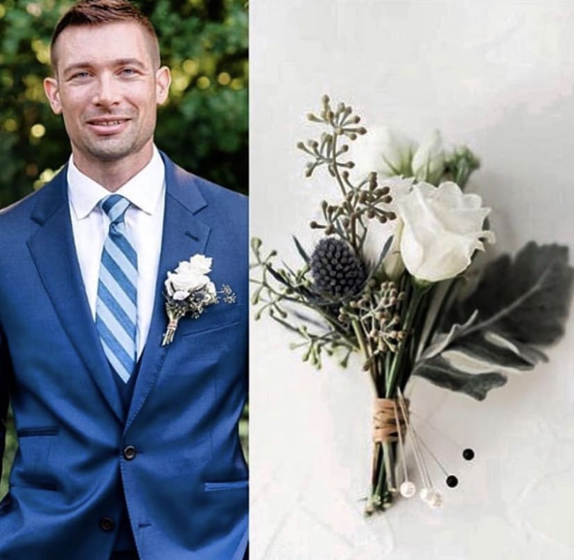 White boutonniere with greenery on a blue suit lapel