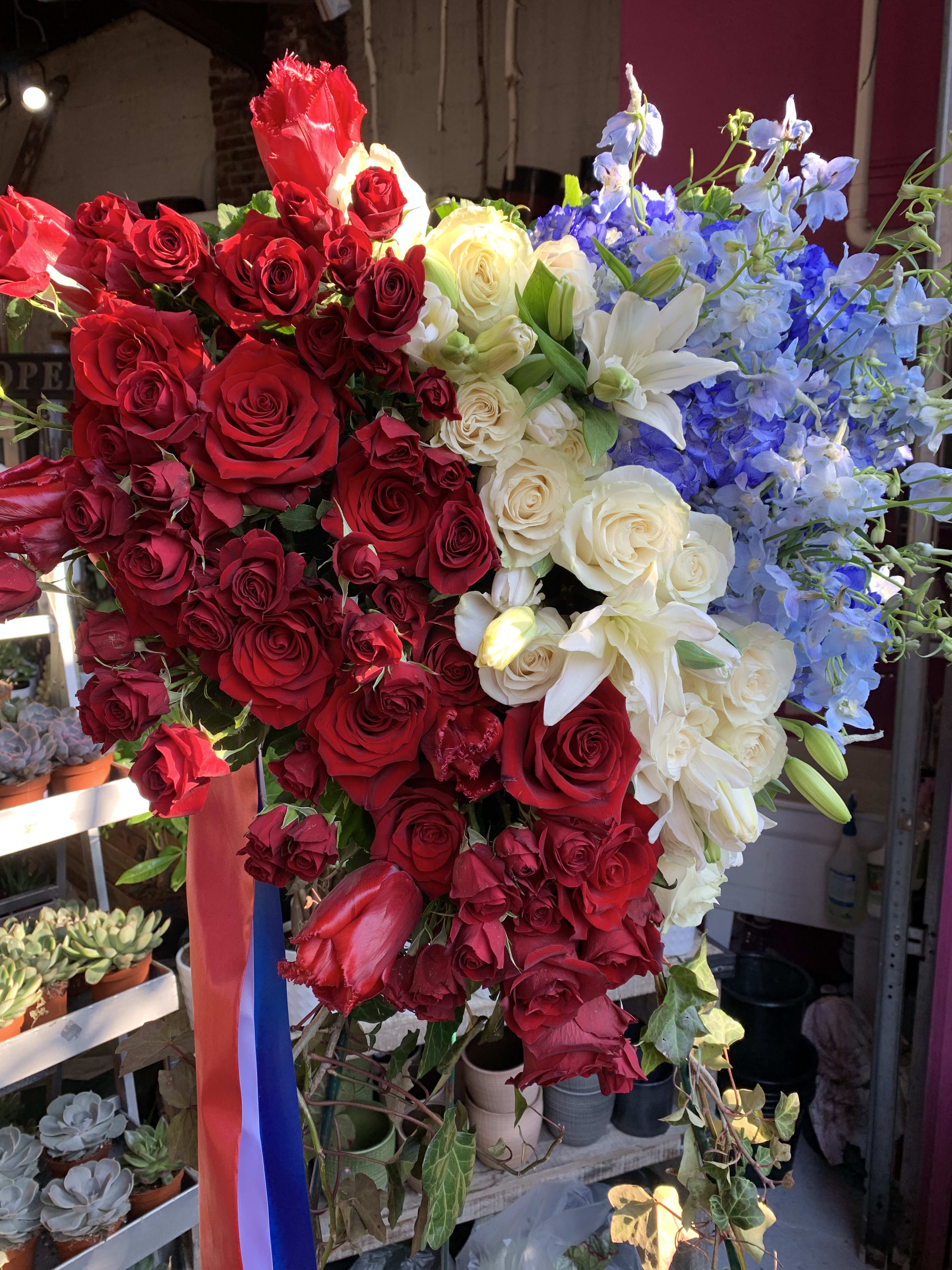 Large bouquet of red, white, and blue flowers on a stand