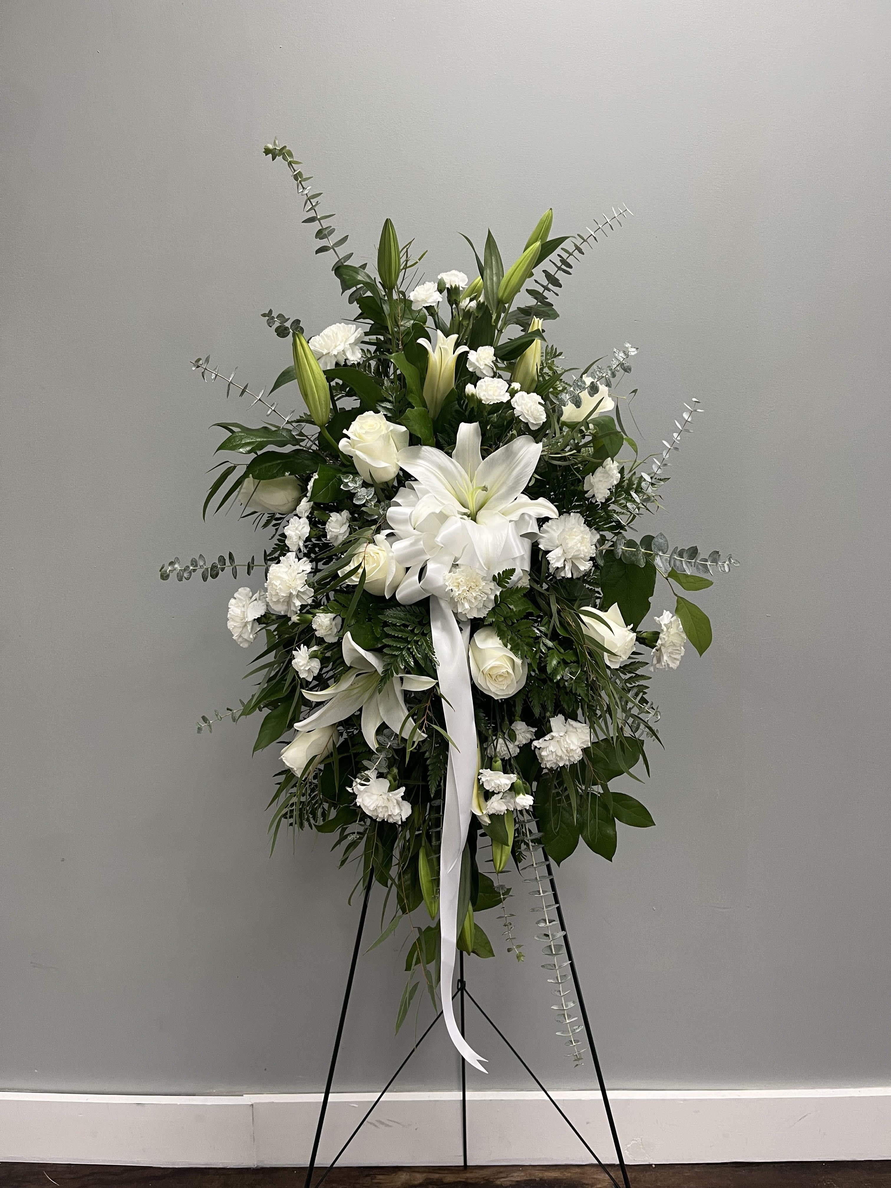 White lilies and roses in a standing spray on an easel