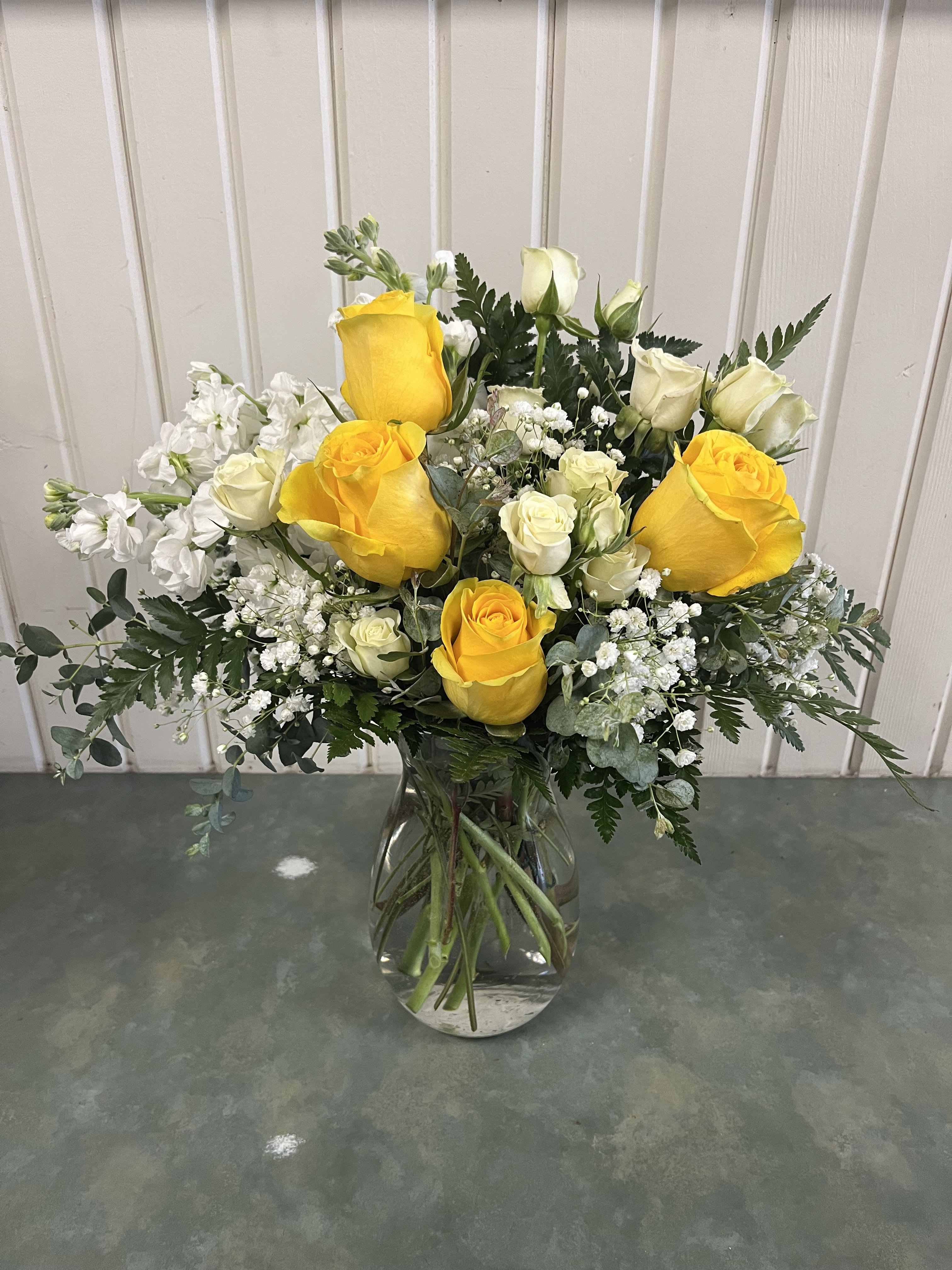Simply Love Bouquet - Yellow roses, white spray roses, stock &amp; assorted greenery vased.  One sided arrangement
