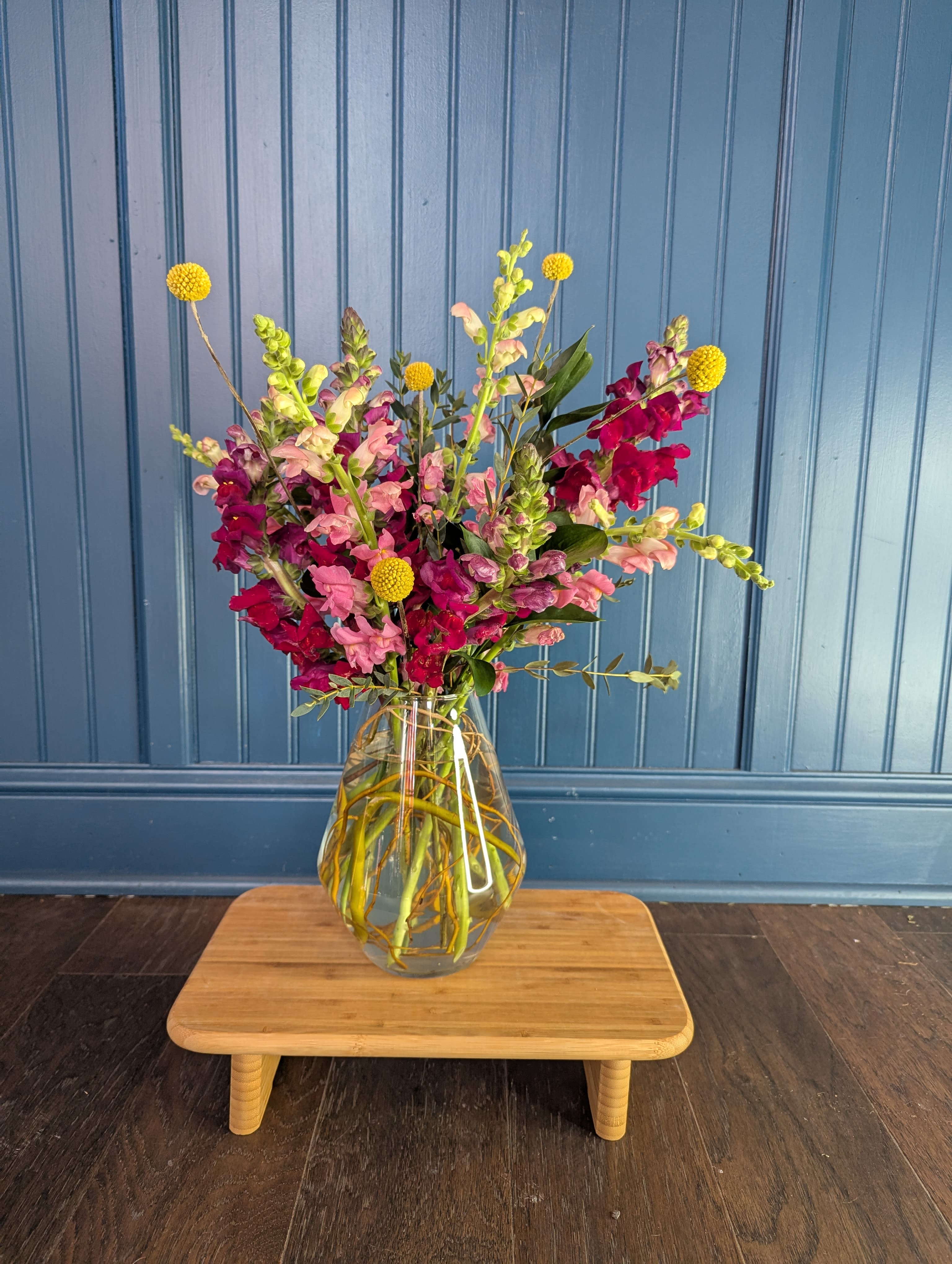 Mixed pink and magenta flowers in a clear glass vase