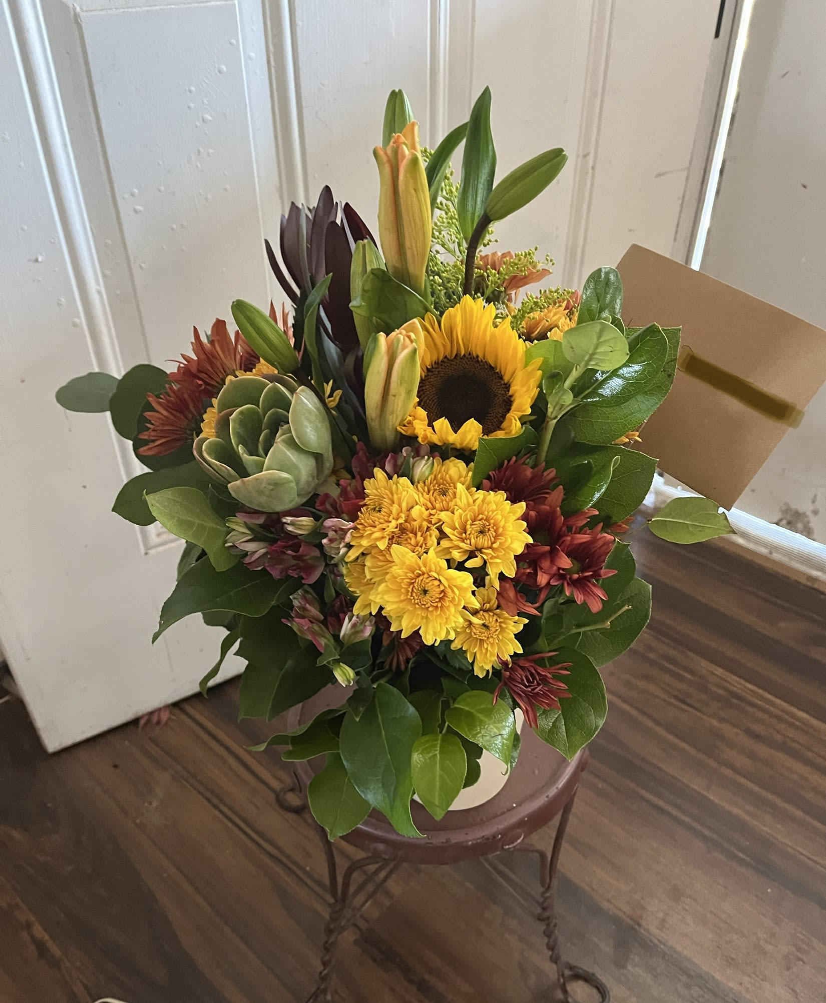 Mixed bouquet with a sunflower, yellow mums, lilies, and a succulent