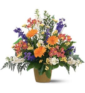 Mixed bouquet in a ribbed basket with orange, purple, white, and yellow flowers