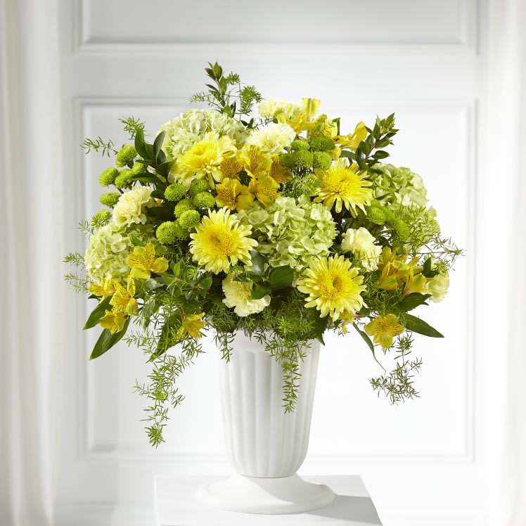 Yellow and white floral arrangement in a white vase