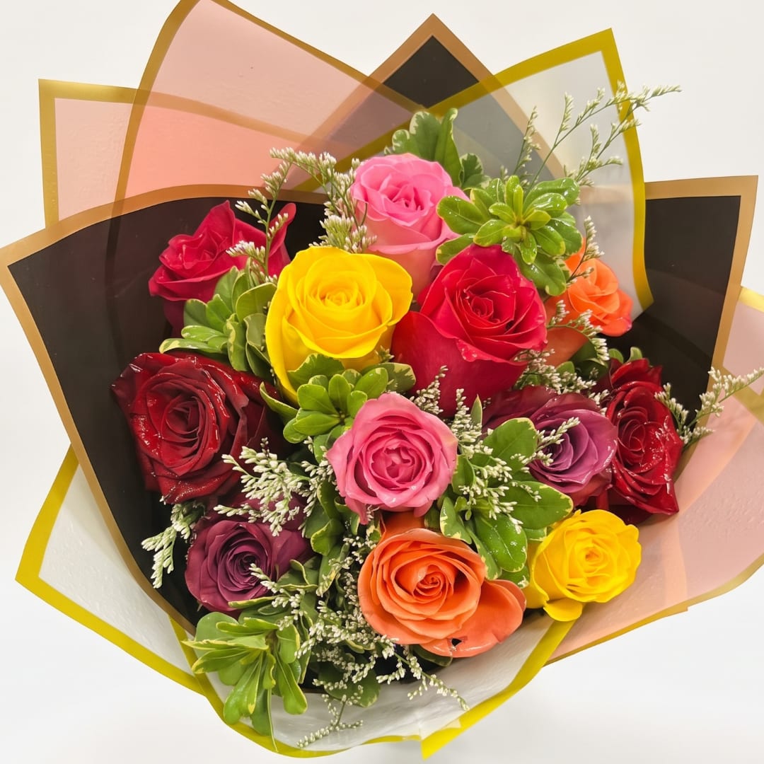 Bouquet of multicolored roses wrapped in translucent paper
