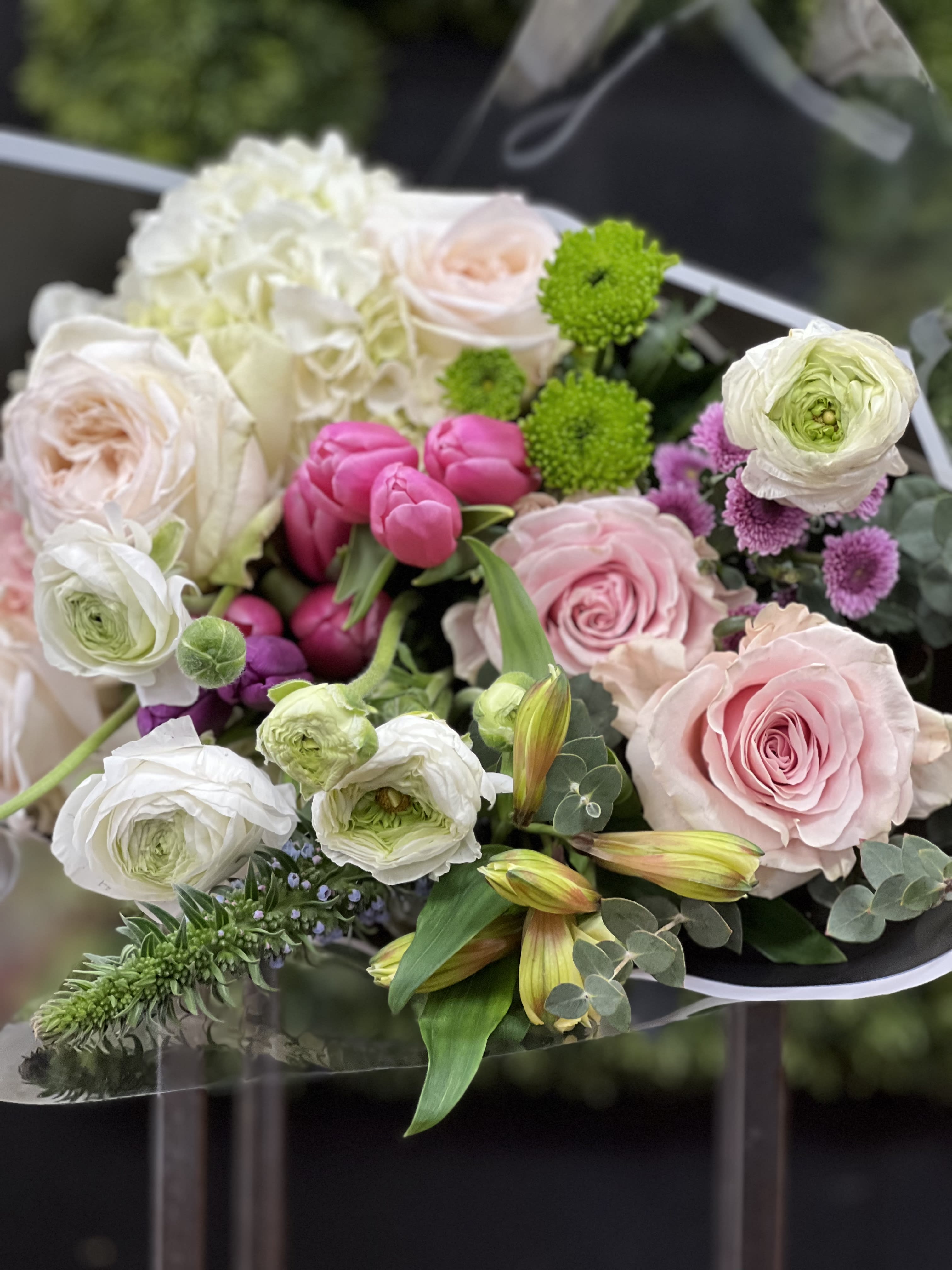 Bouquet of pink and white roses with ranunculus and green accents