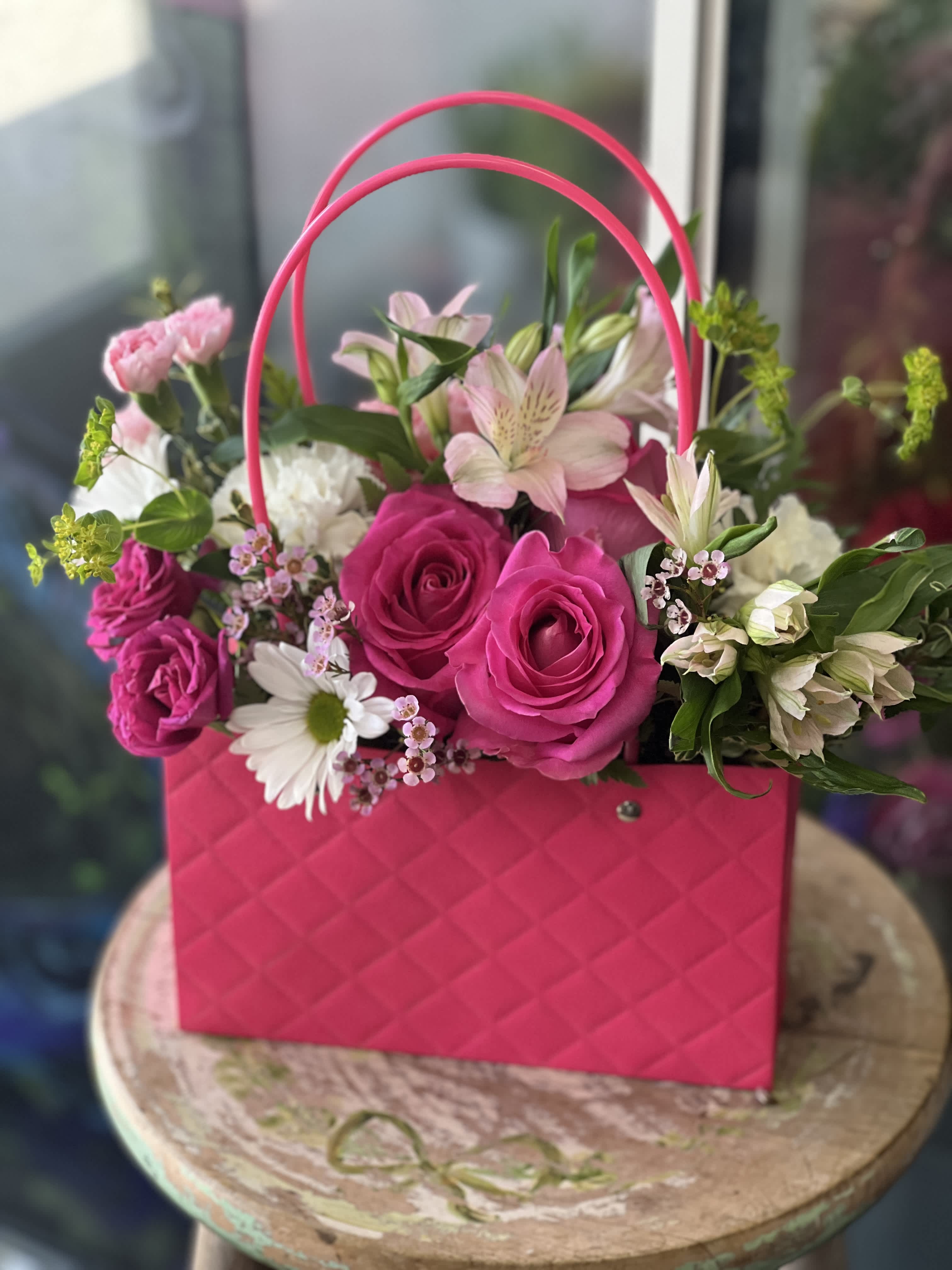 Pink rose bouquet in a bright pink handbag-style container