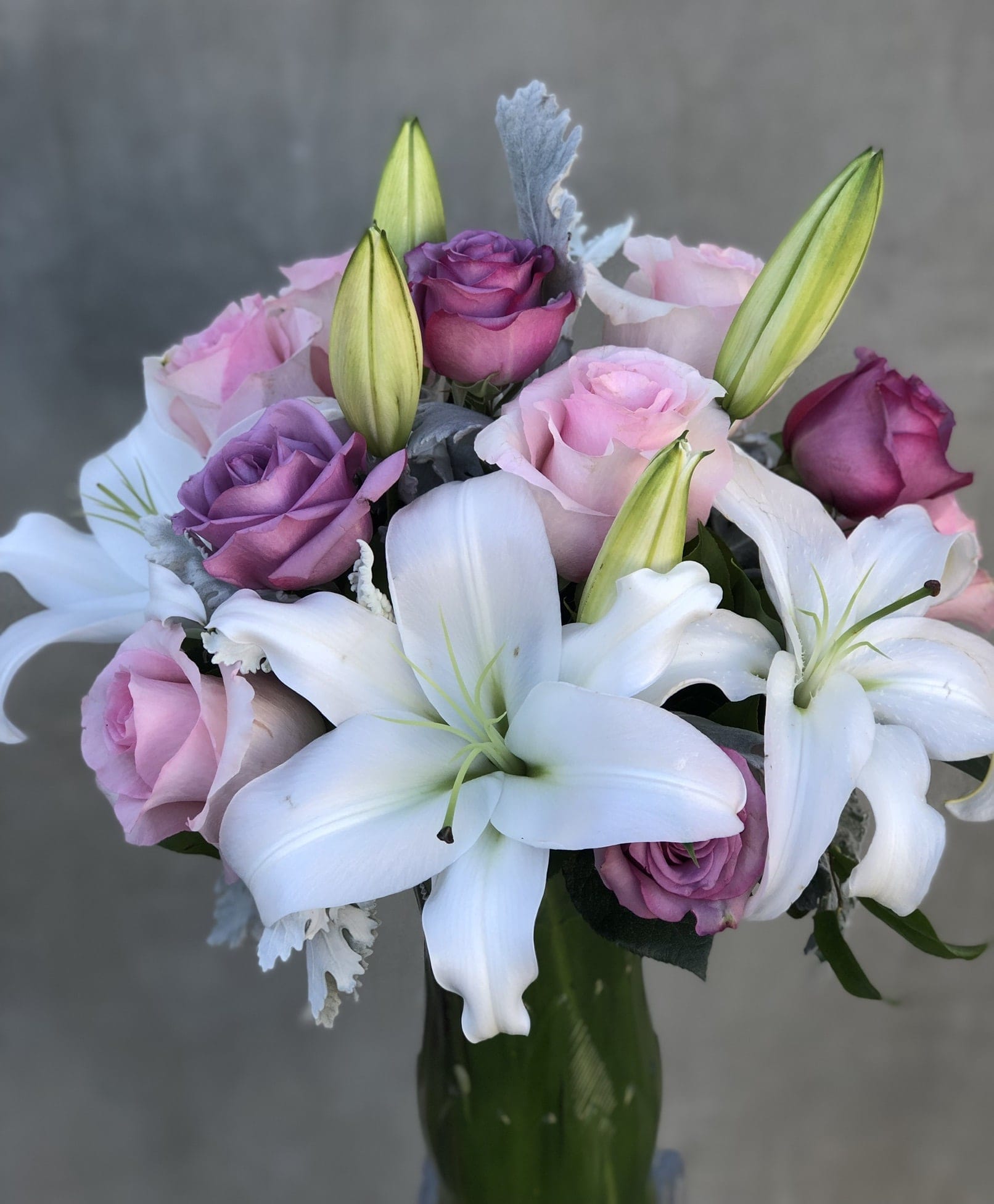 Bouquet of pink and purple roses with white lilies