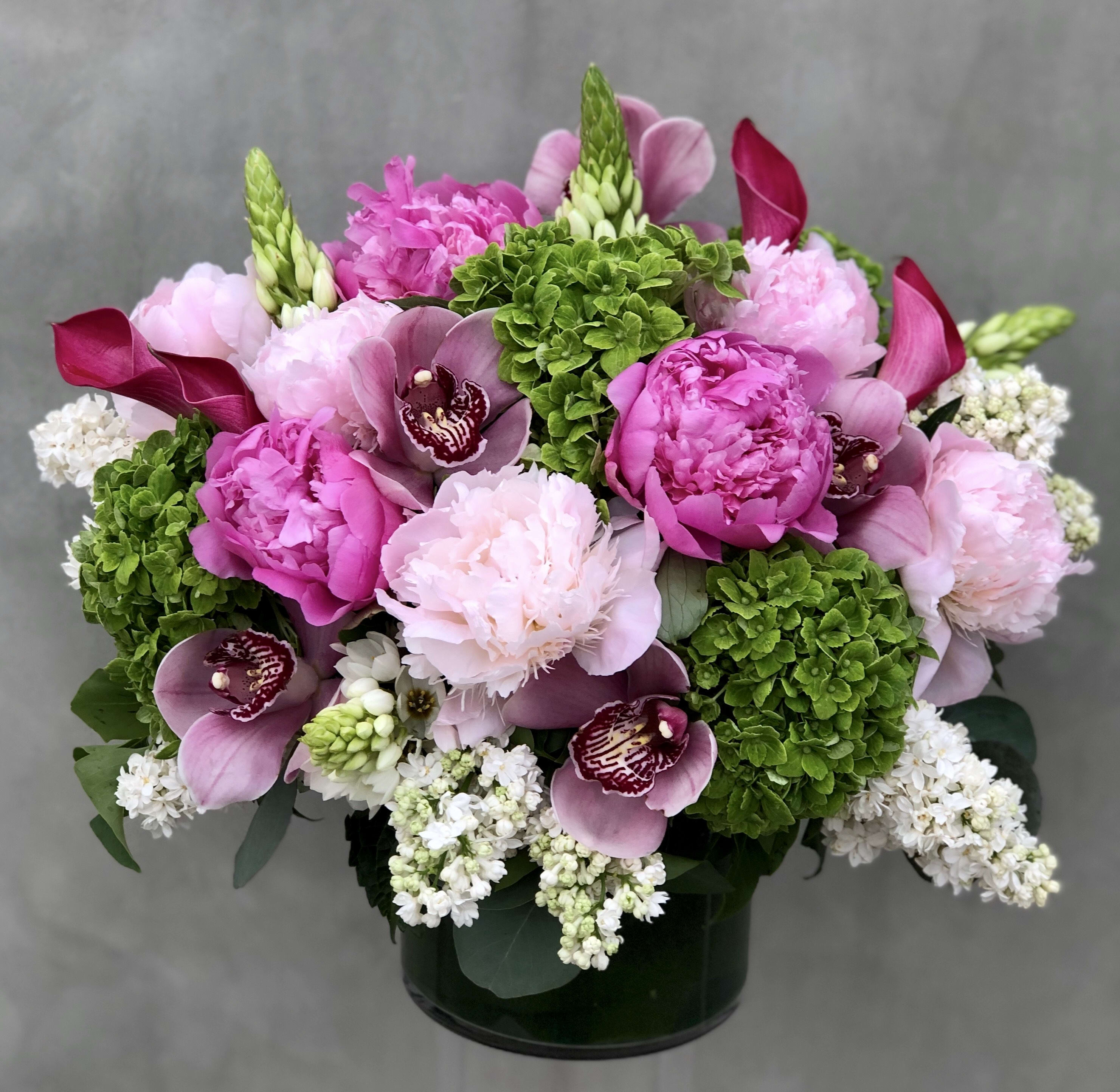 Pink and white floral arrangement in a dark vase