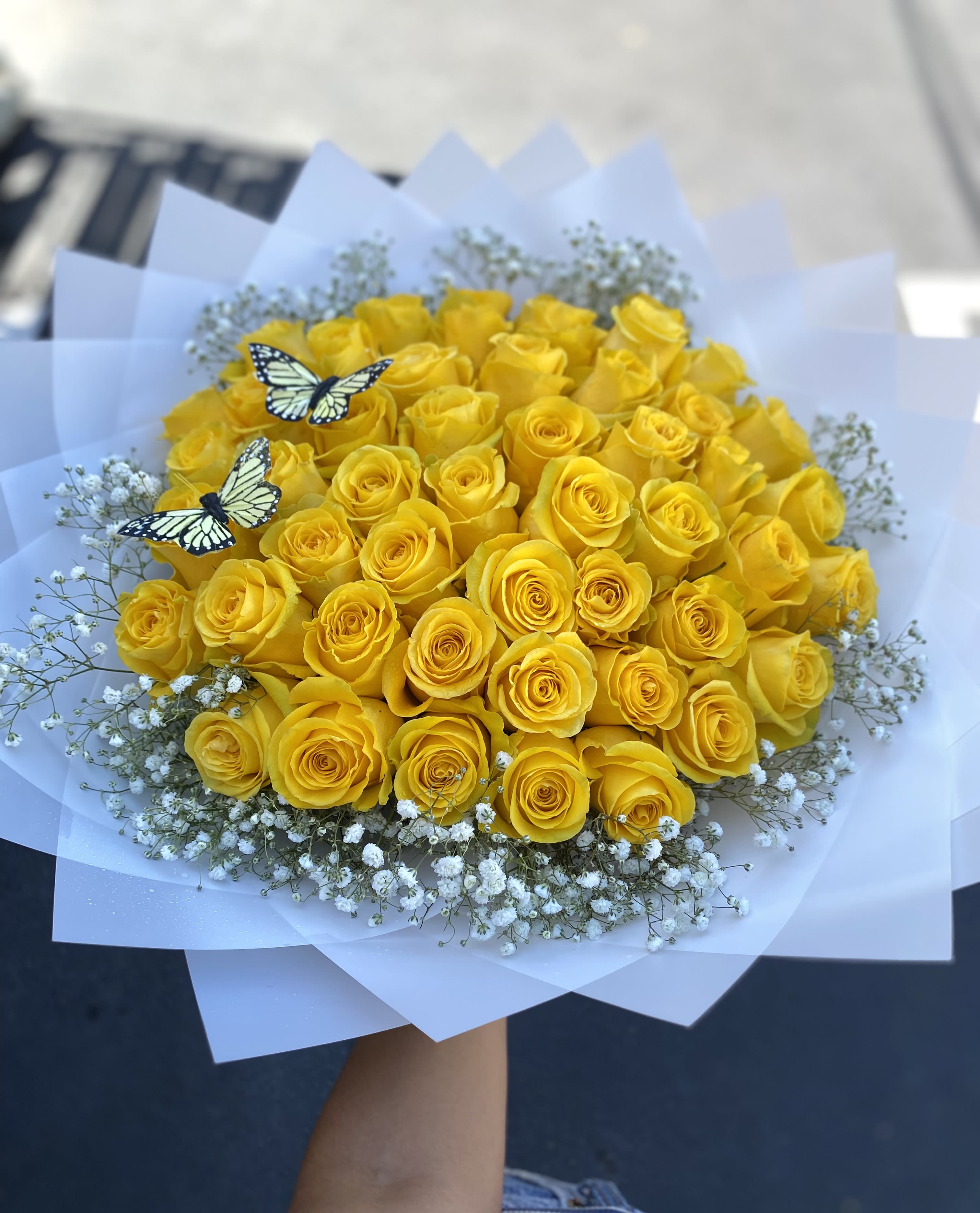 Bouquet of yellow roses with baby’s breath and butterfly picks
