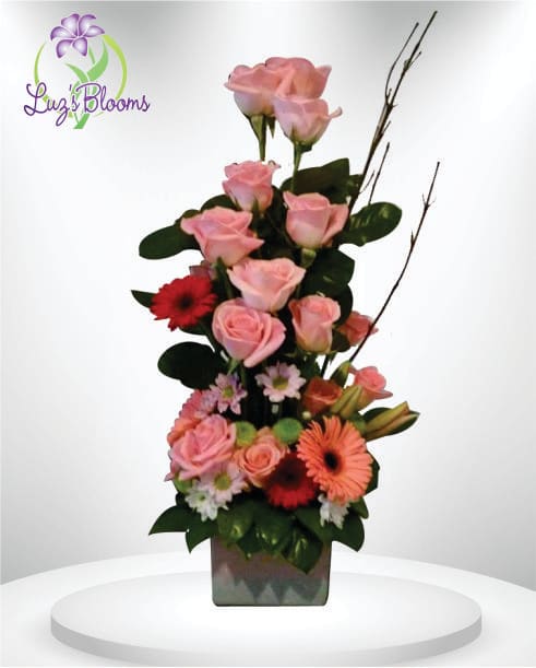 Tall pink rose arrangement with gerbera daisies in a square vase