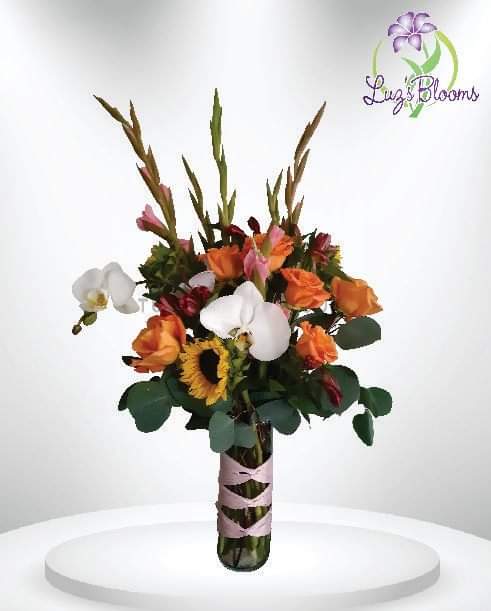 Orange Waves - High quality flowers that'll bring an amazing energy around you. It includes a clear vase with light purple ribbons styled around the arrangement.