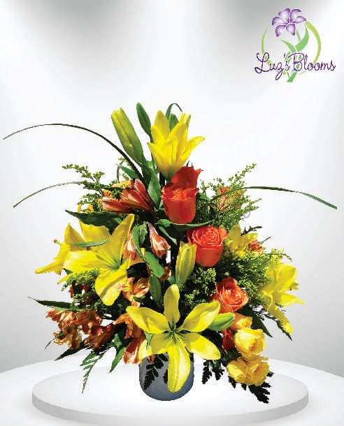 Bright bouquet of yellow lilies and orange roses in a vase