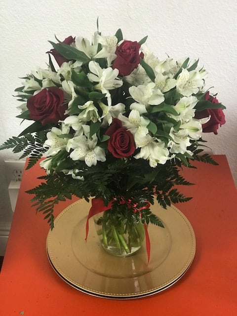 Bouquet of red roses and white alstroemeria in a glass vase