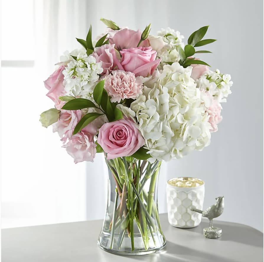 Pink roses and white hydrangeas in a clear glass vase