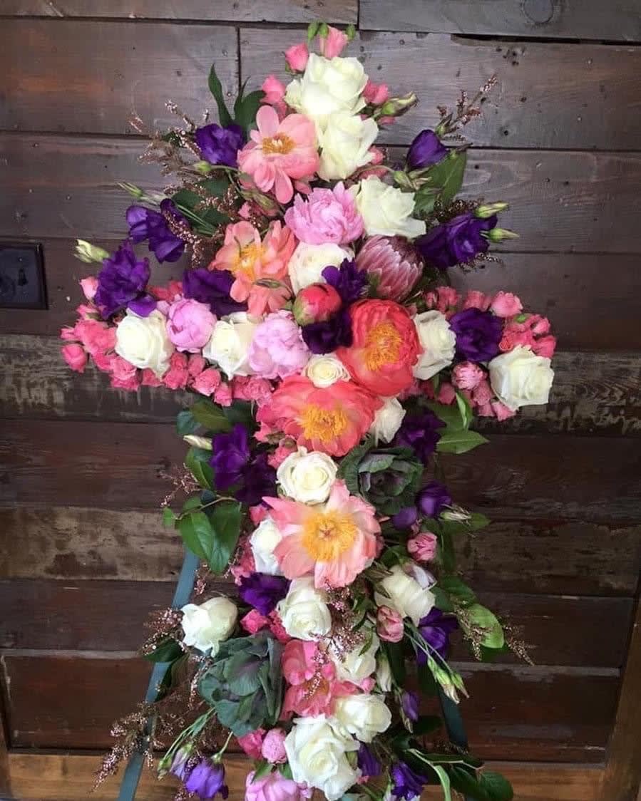 Cross-shaped floral arrangement with pink, white, and purple flowers