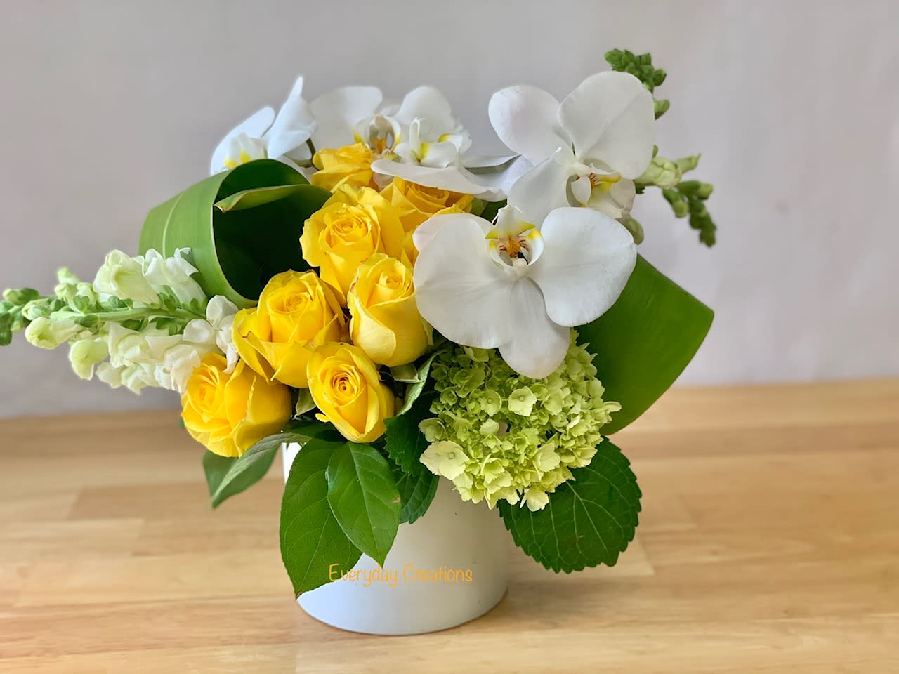 EC09 - Modern Design - Modern Design Bouquet – Elegant Yellow and White Flower Arrangement in Ceramic Vase | Tustin, Irvine, Ca Flower Delivery Bring modern elegance to your space with our Modern Design Bouquet, a sophisticated flower arrangement available for same-day flower delivery in Irvine, CA and surrounding areas. This premium bouquet features a striking mix of yellow and white blooms, including Phalaenopsis orchids, roses, green trick dianthus, snapdragons, and aspidistra leaves—all beautifully arranged in a sleek white ceramic vase. Designed with clean lines and a minimalist aesthetic, this modern flower arrangement is ideal for home décor, office settings, corporate events, or special occasions like birthdays, anniversaries, and thank-you gifts. Order this elegant floral design online from your trusted local Tustin florist and enjoy fast, reliable flower delivery with exceptional quality and service.