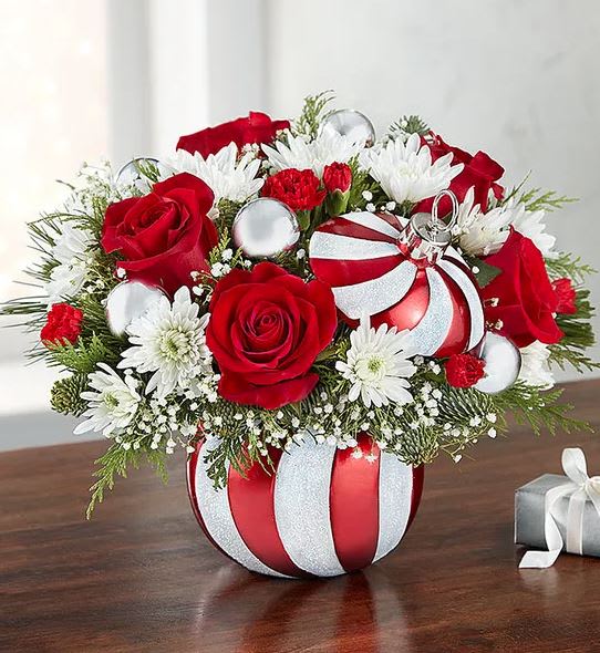 Red roses and white daisies in a striped ornament vase