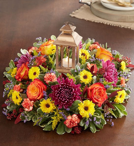Round floral wreath with a lantern candle centerpiece