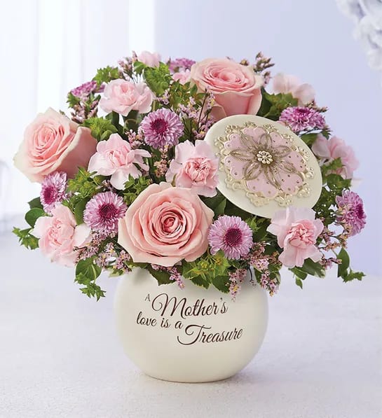 Pink roses and purple flowers in a cream vase with a Mother's Day message