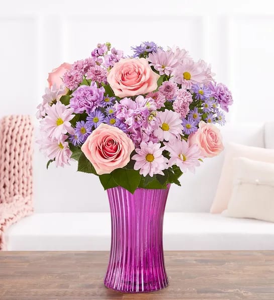 Pink roses and lavender daisies in a purple vase