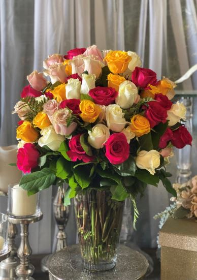 Large bouquet of multicolored roses in a clear glass vase