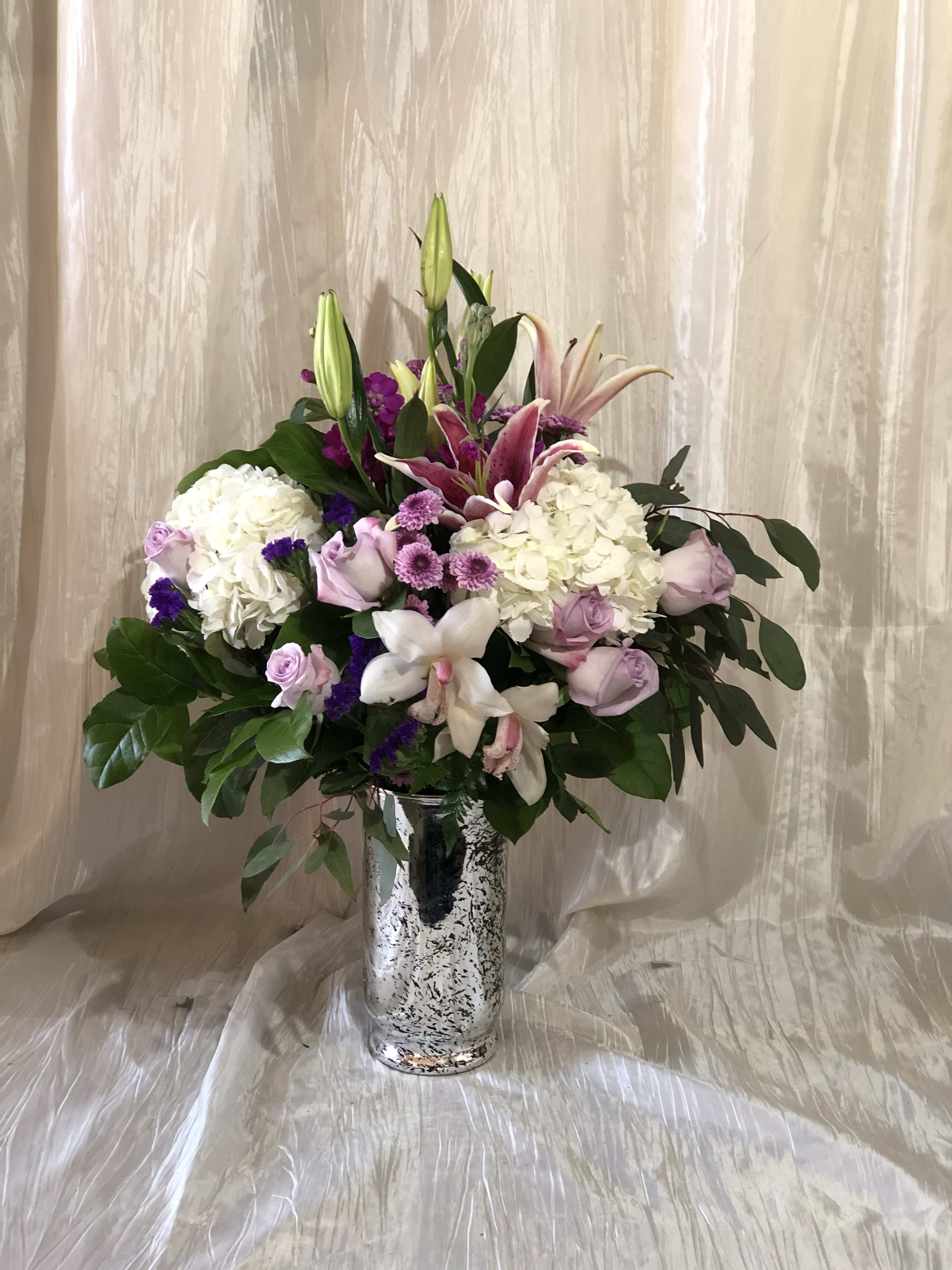 Mixed pink and white floral arrangement in a silver vase