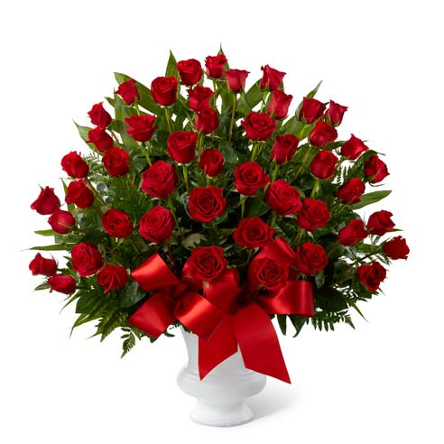 Large bouquet of red roses in a white vase with a red ribbon