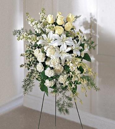 White and pale yellow floral standing spray on a black easel