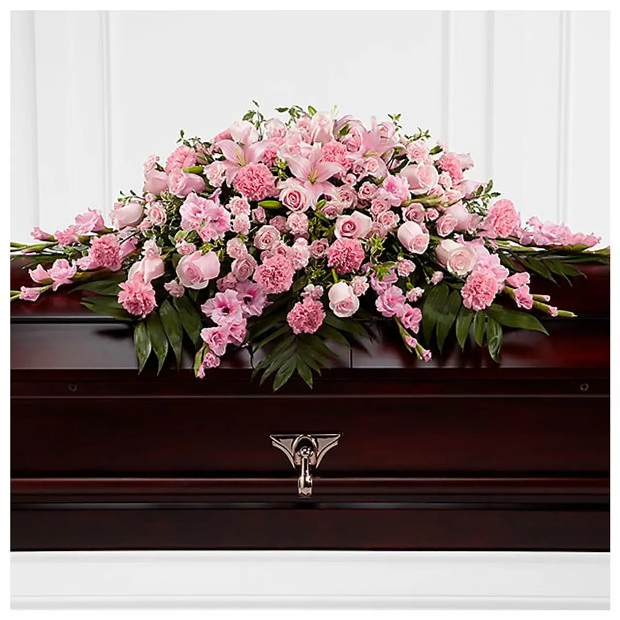 Pink floral spray arranged on a dark casket