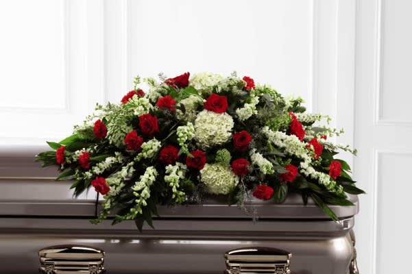 Red and white floral casket spray on a silver casket