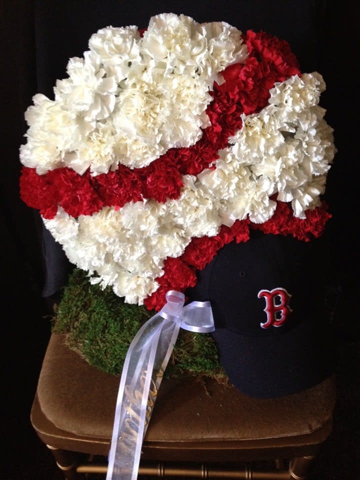 Red and white carnation arrangement shaped like a baseball cap
