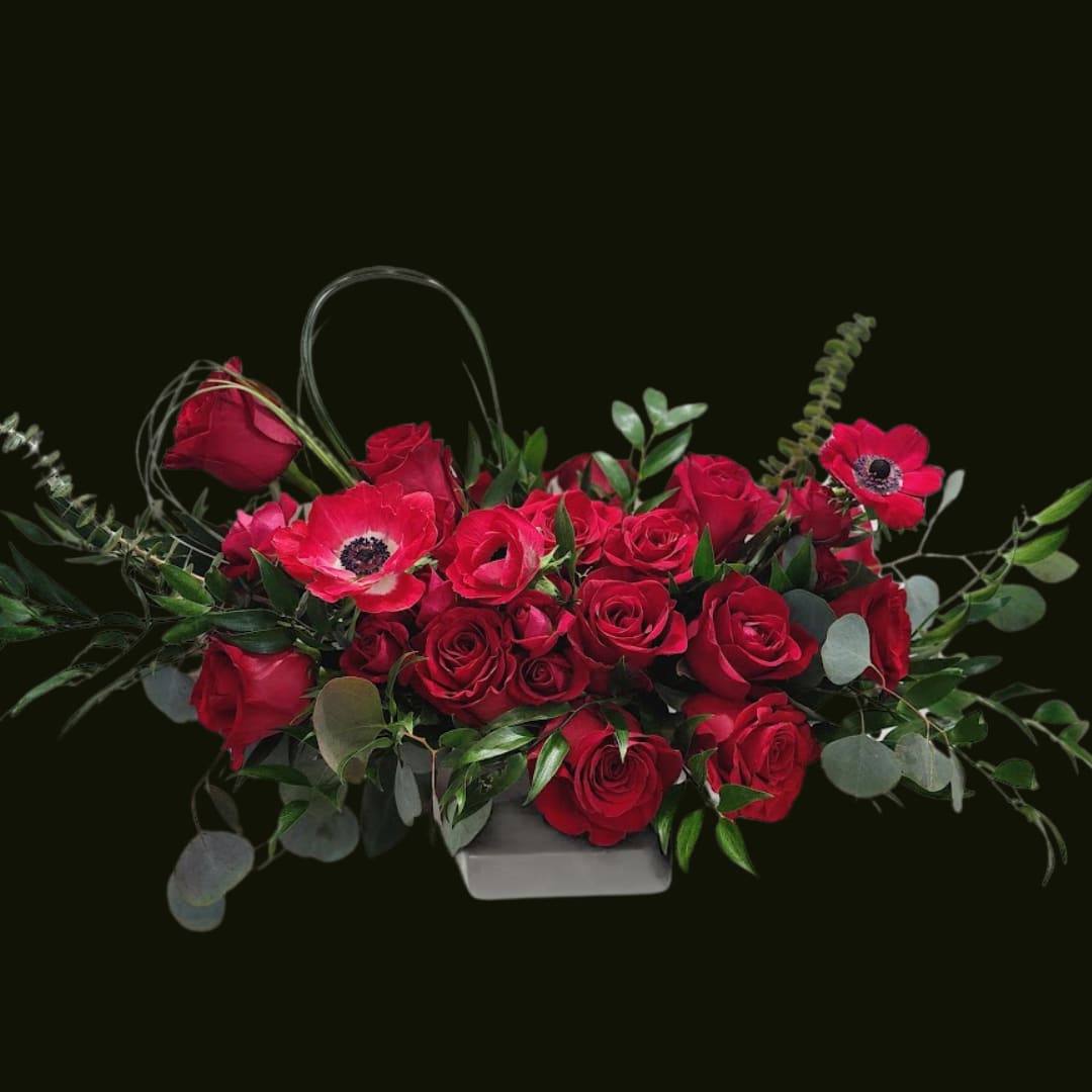 Red roses and red anemones in a low rectangular container