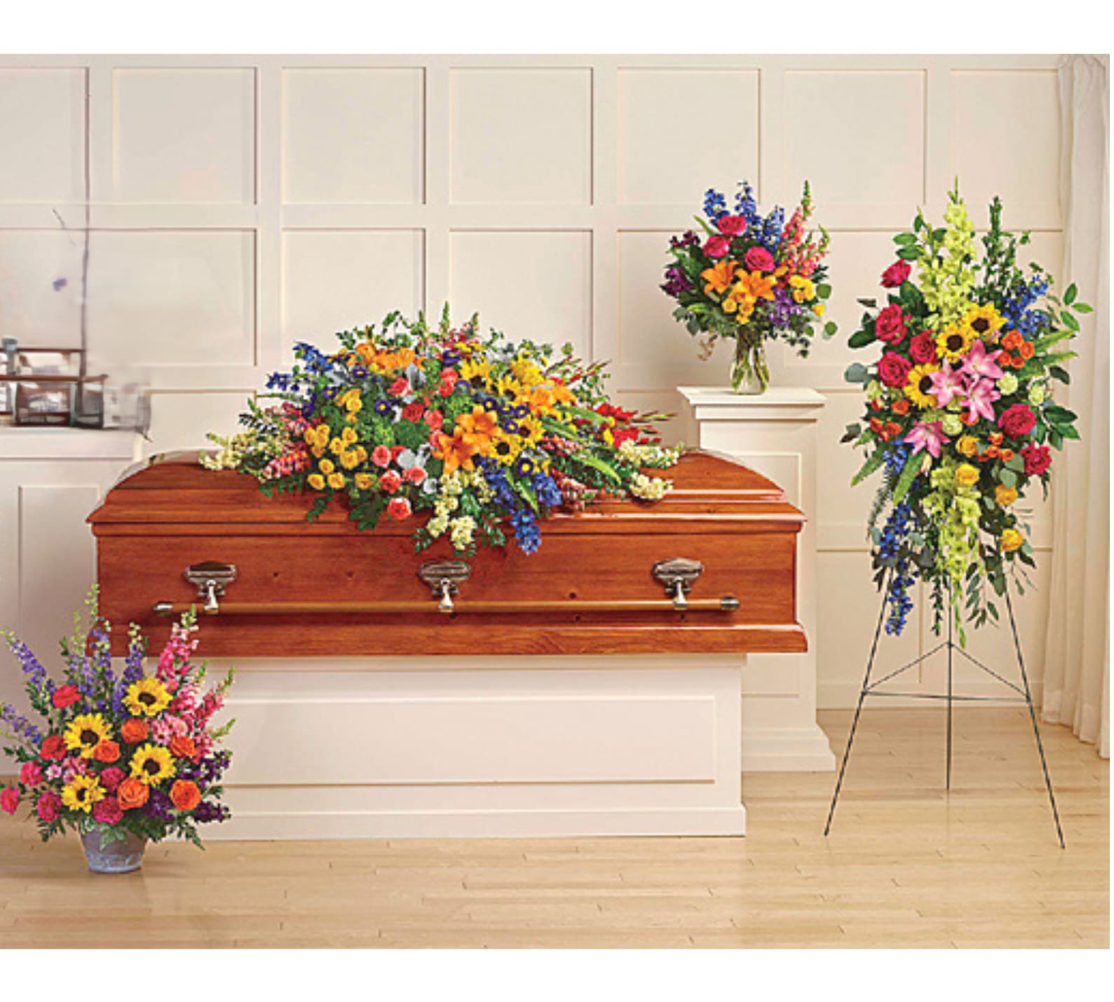 Colorful funeral casket spray with matching standing arrangements