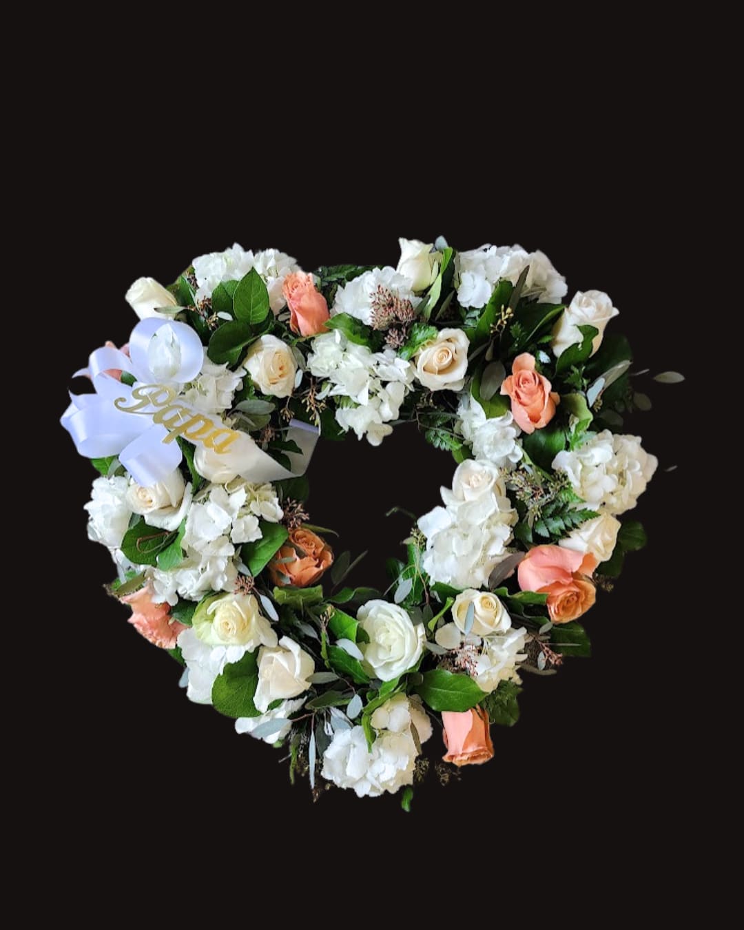 Heart-shaped floral wreath with white and peach roses