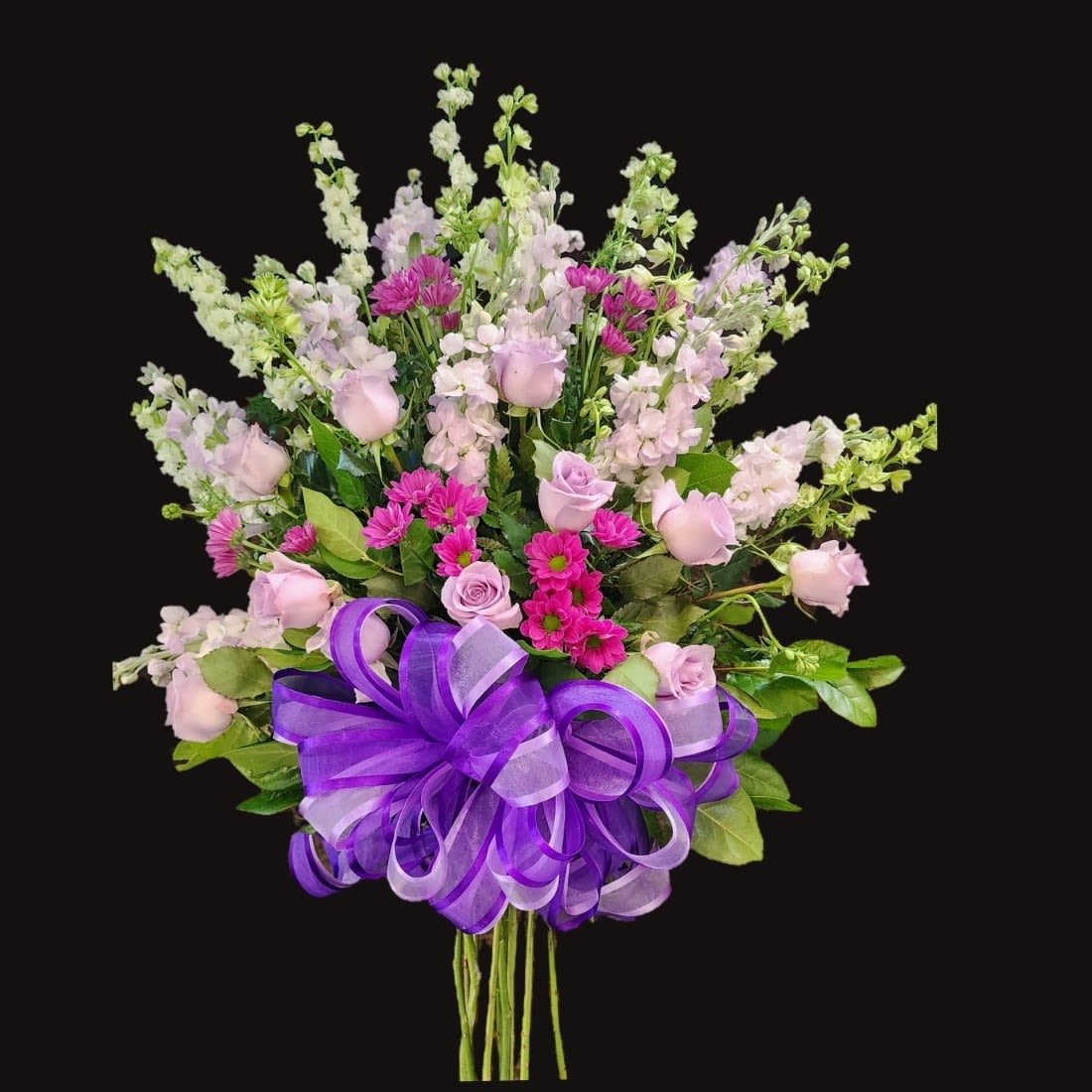 Bouquet of pink and lavender flowers with a purple ribbon bow