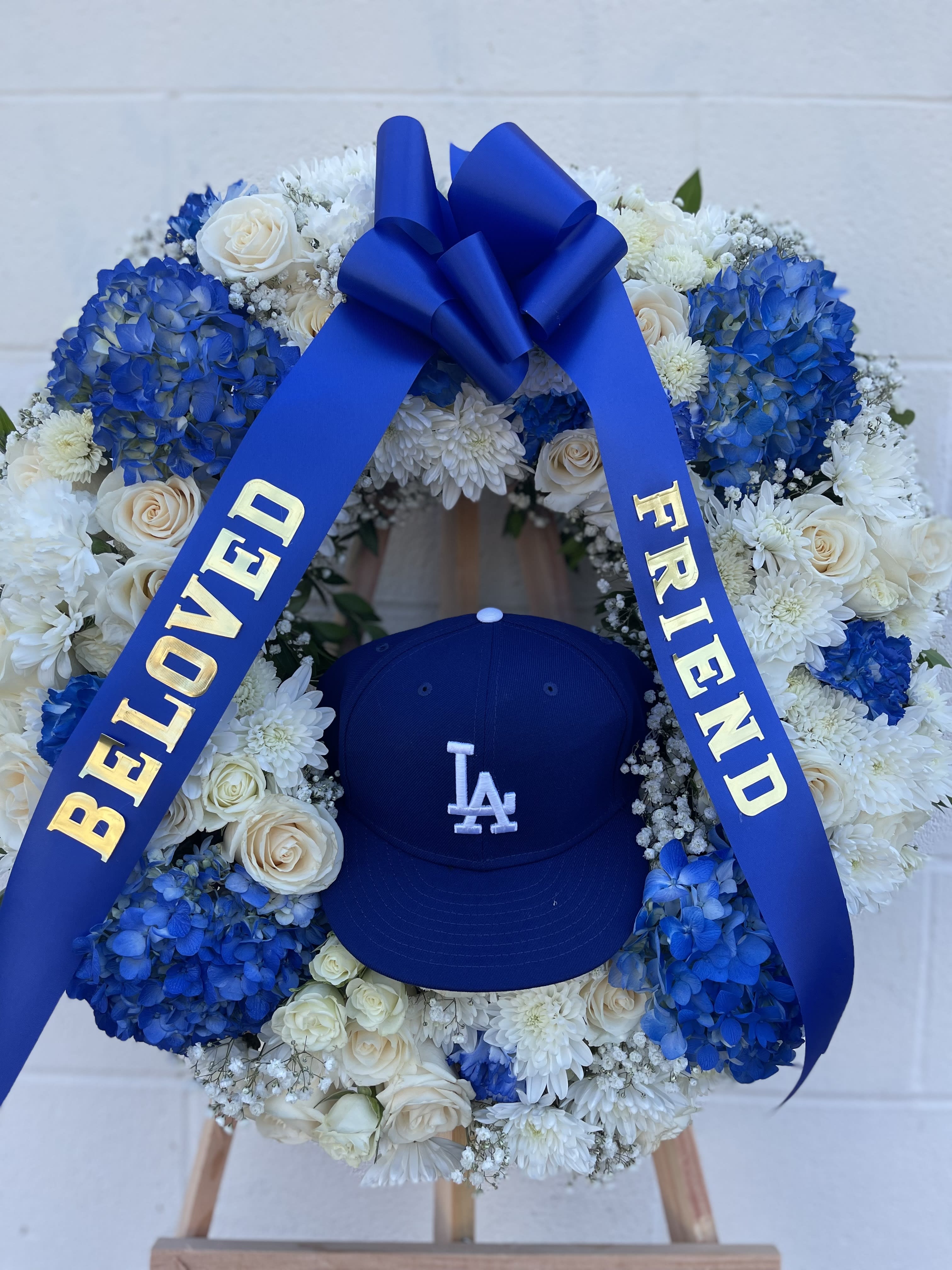 Blue and white floral wreath with a ribbon and baseball cap
