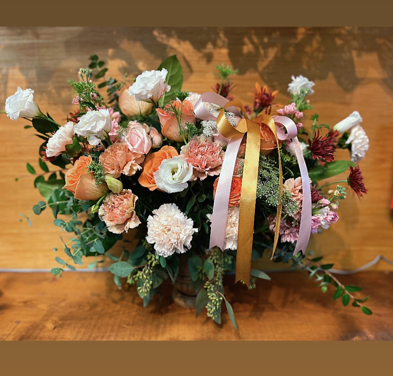 Peach and white mixed flower arrangement with ribbon in a vase