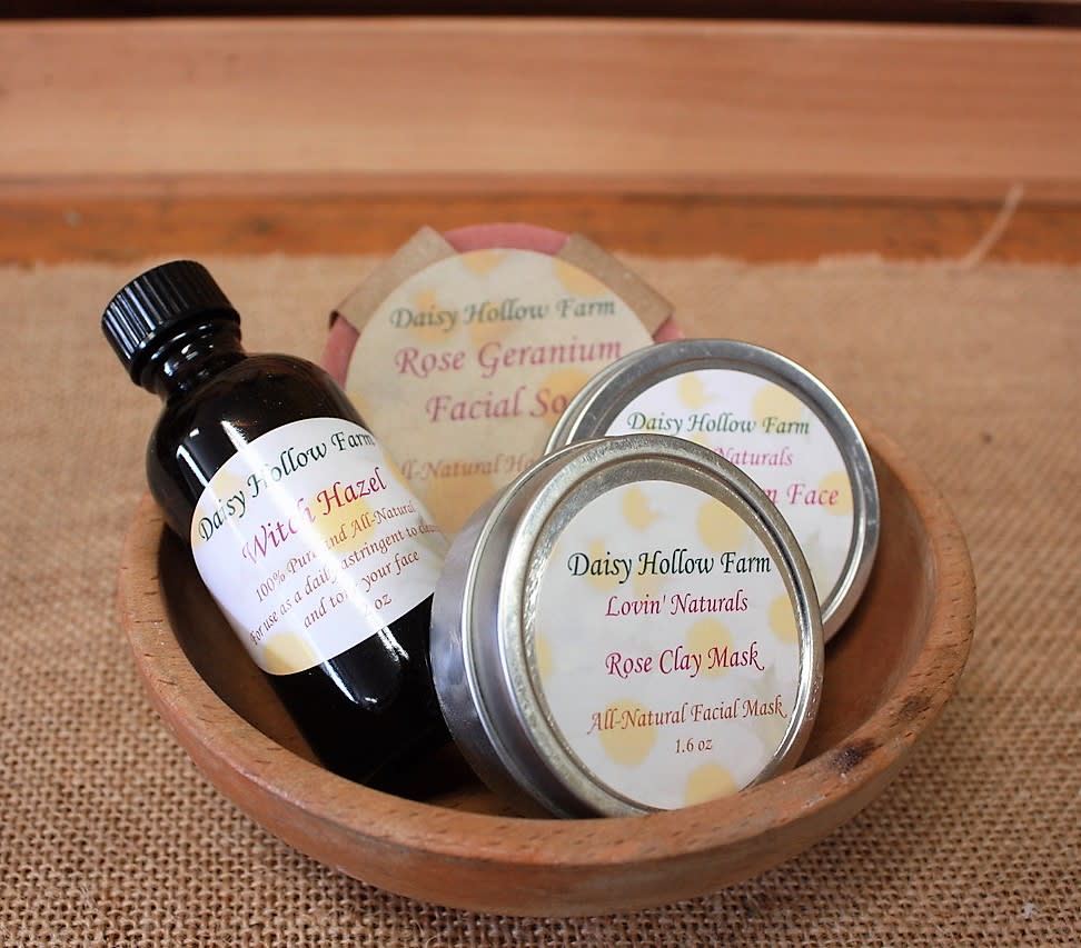 Wooden bowl holding a bottle and tins of facial skincare products